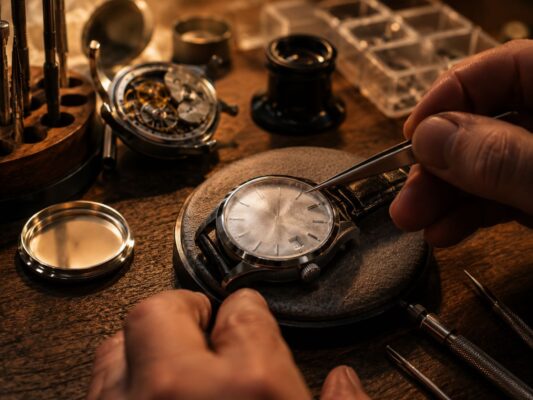 手錶進水鏡面內側起霧,放在暖色調專業維修工作台上等待除水